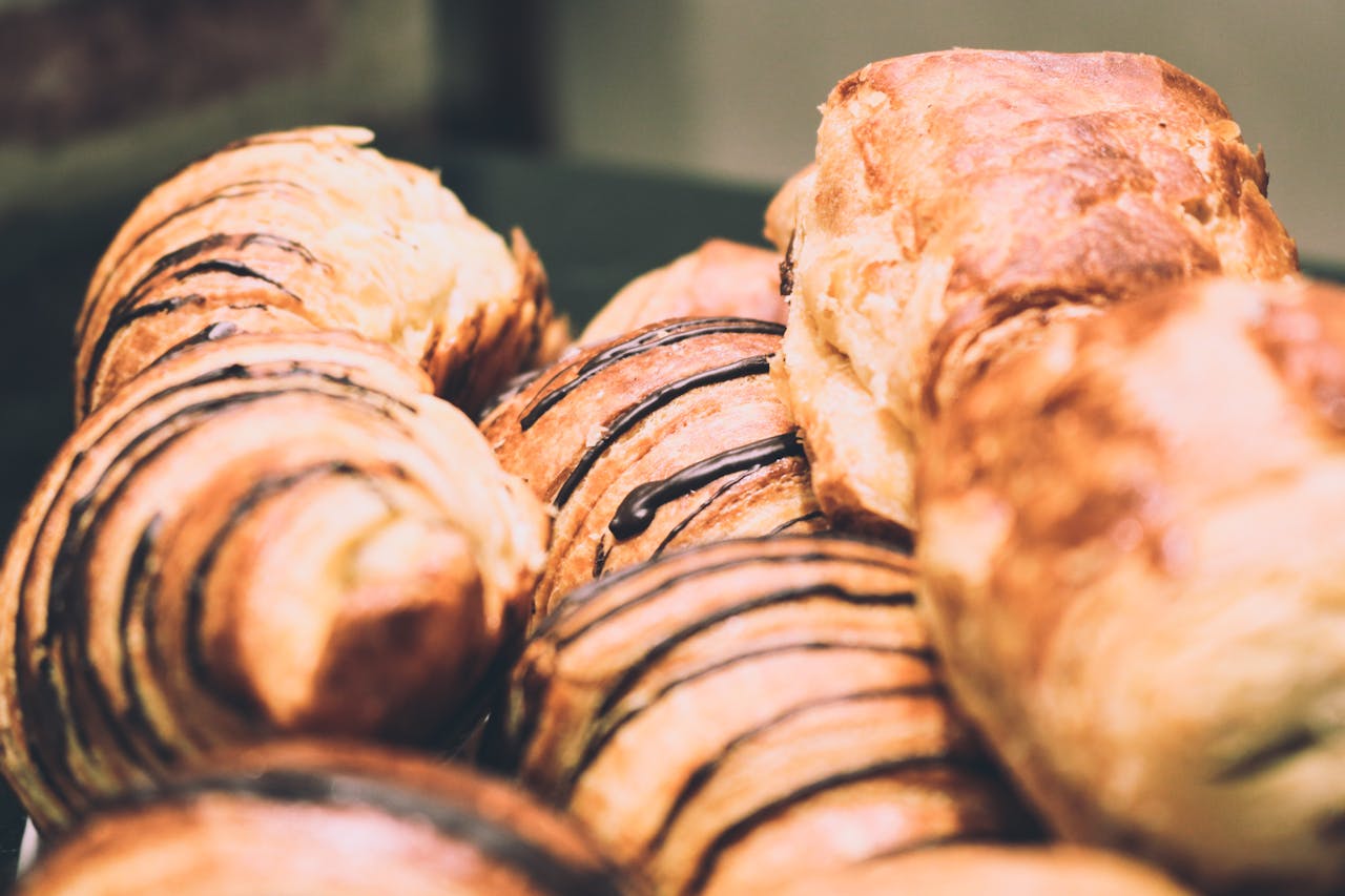 our-story-01 Delicious freshly baked pastries with chocolate drizzle, showcasing a sweet indulgence.
